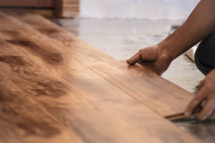 cClose up of a man installing hardwood floor boards